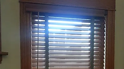 Las persianas de madera aportan un toque sutil y realzan la decoración al combinarse con el papel tapiz y las alfombras