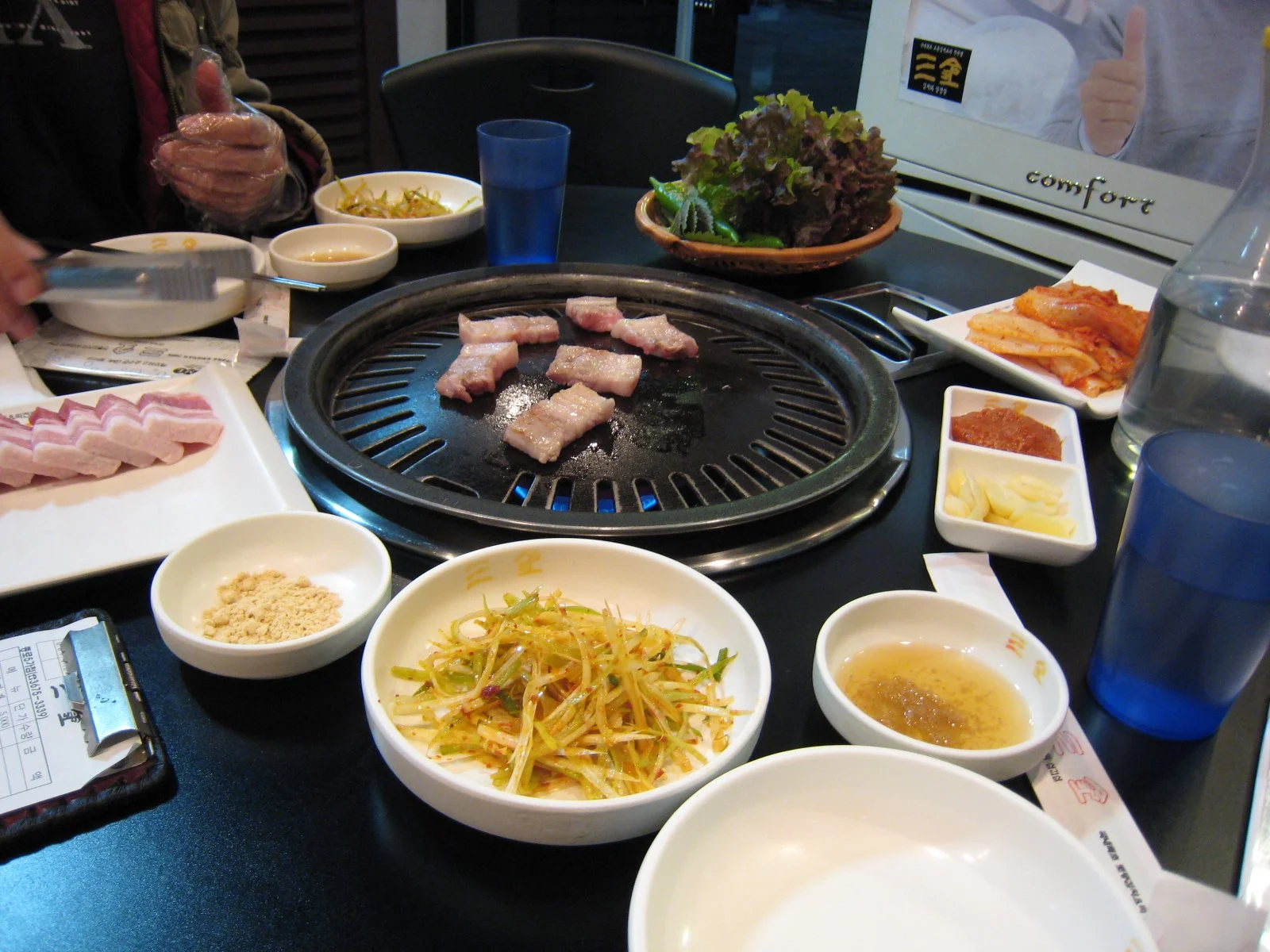 불판 위에서 익고 있는 삼겹살과 돼지고기 구이